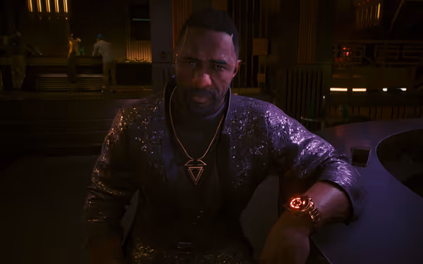 A man in a sequinned suit sits at a purple lit bar.