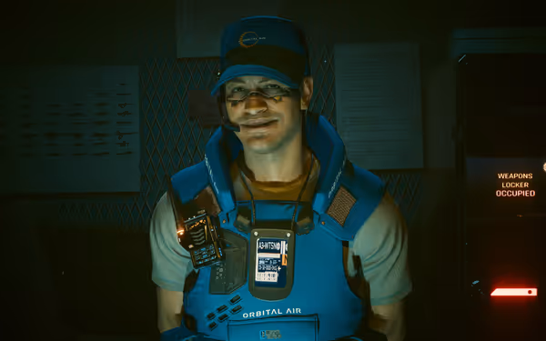 A smiling man in blue Orbital Air uniform stands beside an occupied weapons locker.