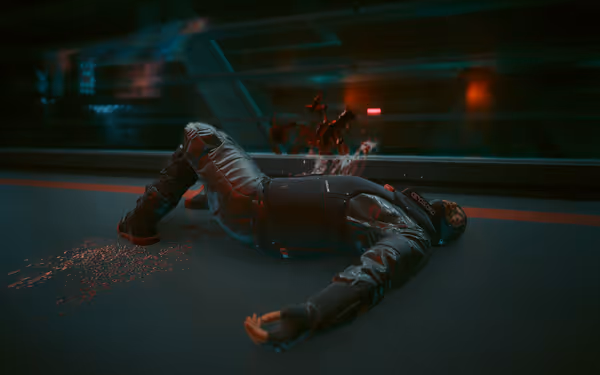 A man in futuristic armor lies dead on the floor with blood splattered behind him.
