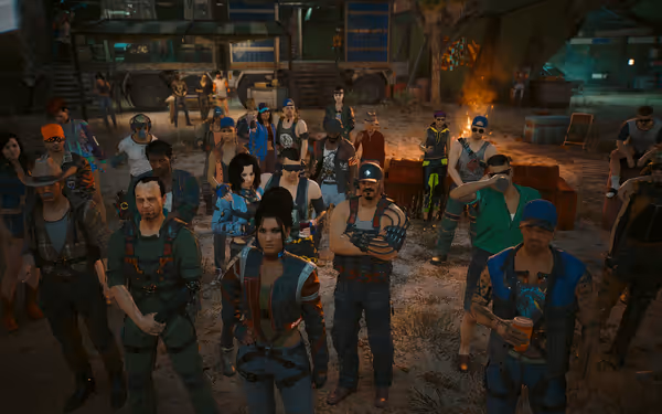 A diverse group of people stand closely together outdoors, facing forward near a campfire.