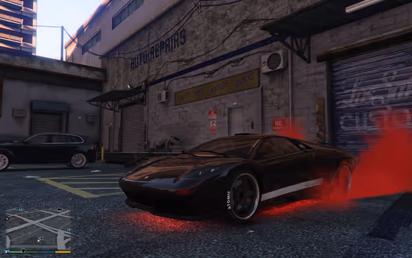 A black sports car with red underglow is parked outside an auto repair garage.